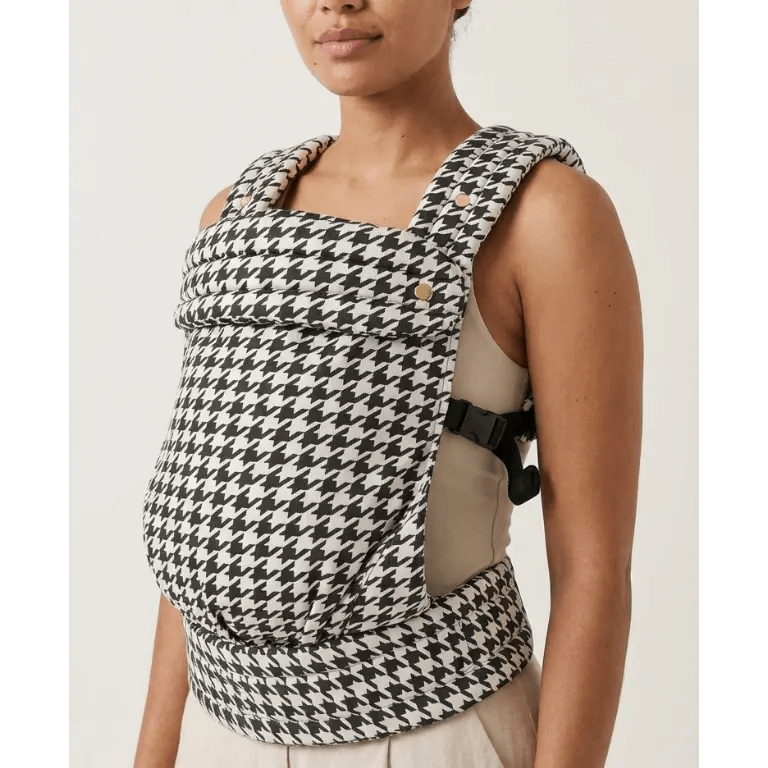 Woman wearing black and white houndstooth patterned baby carrier