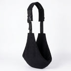 Black corduroy baby carrier sling with adjustable strap on white background